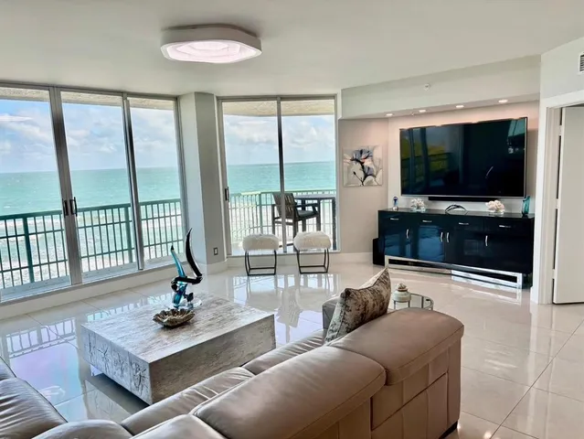 a living room with furniture a flat screen tv and a large window