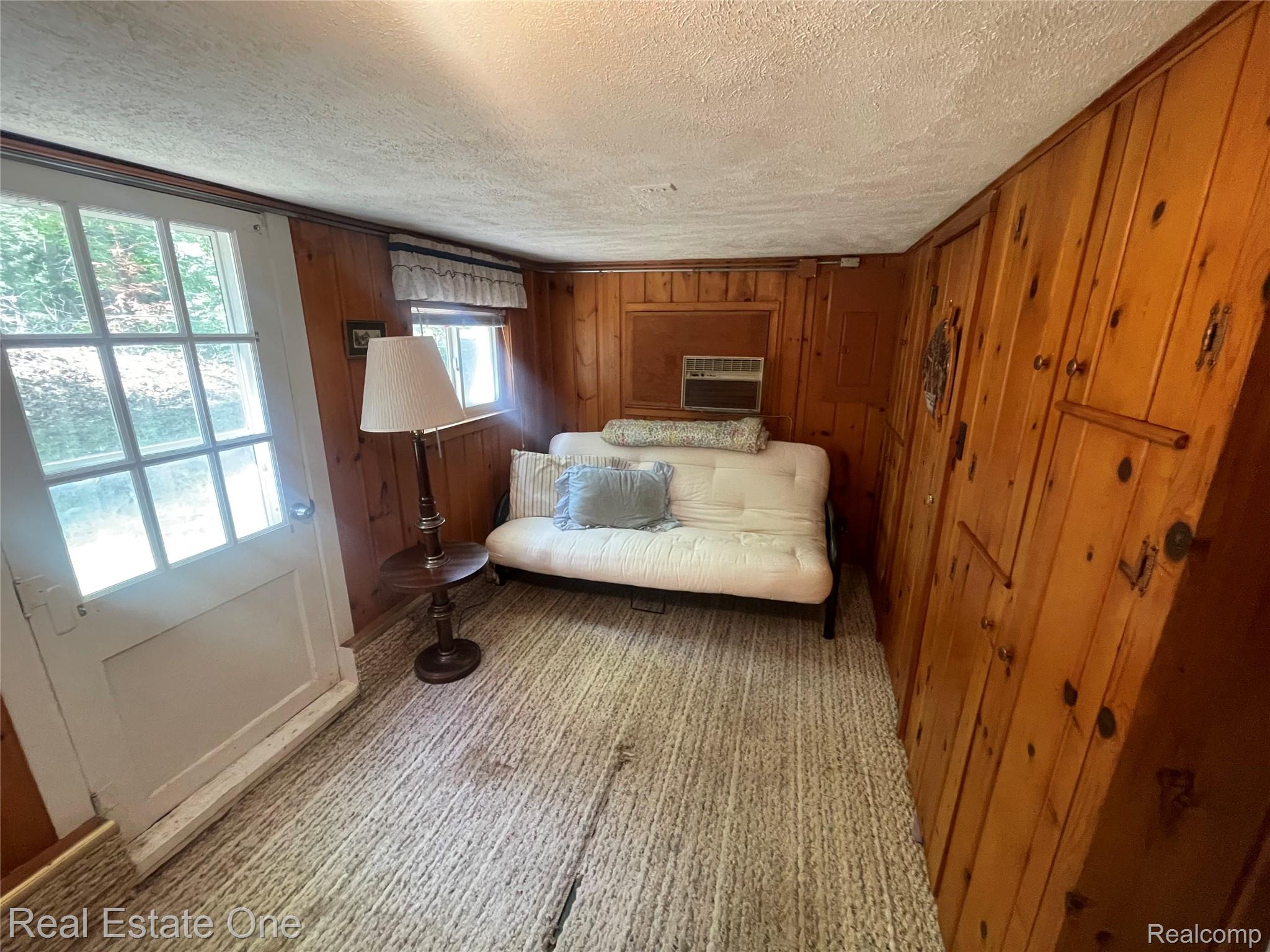 2596 Fox Road Lincoln, MI 48742 - Photo 20 of 54 Room featuring wood paneled walls, a windowed exterior door, and a built-in air conditioning unit