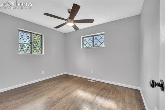 2004 Monterey Road Colorado Springs, CO 80910 - Photo 16 of 27 Empty room with healthy amount of natural light, a ceiling fan, and wood finished floors
