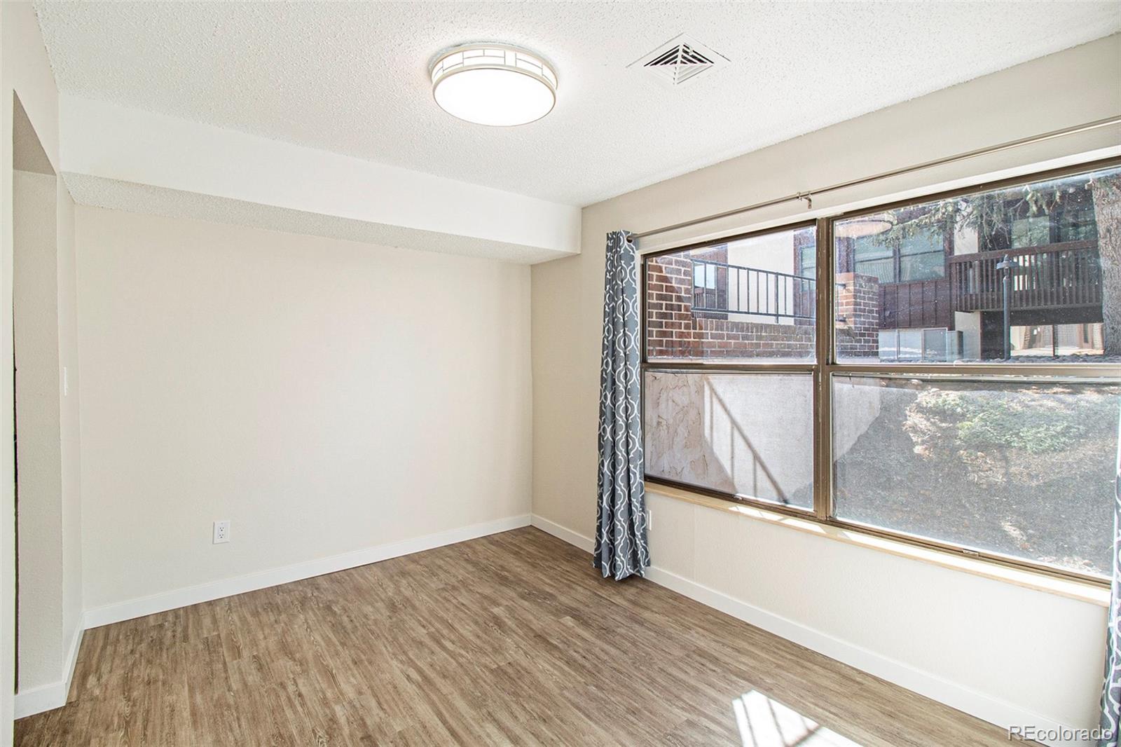 500 Manhattan Drive, Unit B1 Boulder, CO 80303 - Photo 7 of 24 an empty room with wooden floor and windows