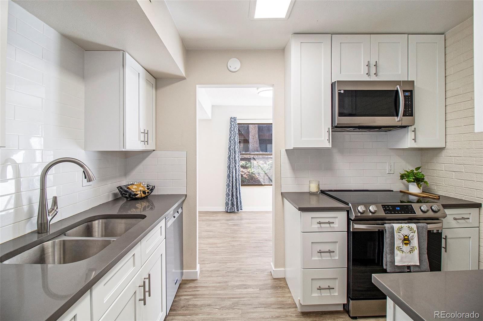 500 Manhattan Drive, Unit B1 Boulder, CO 80303 - Photo 9 of 24 a kitchen with stainless steel appliances granite countertop a sink and a stove top oven