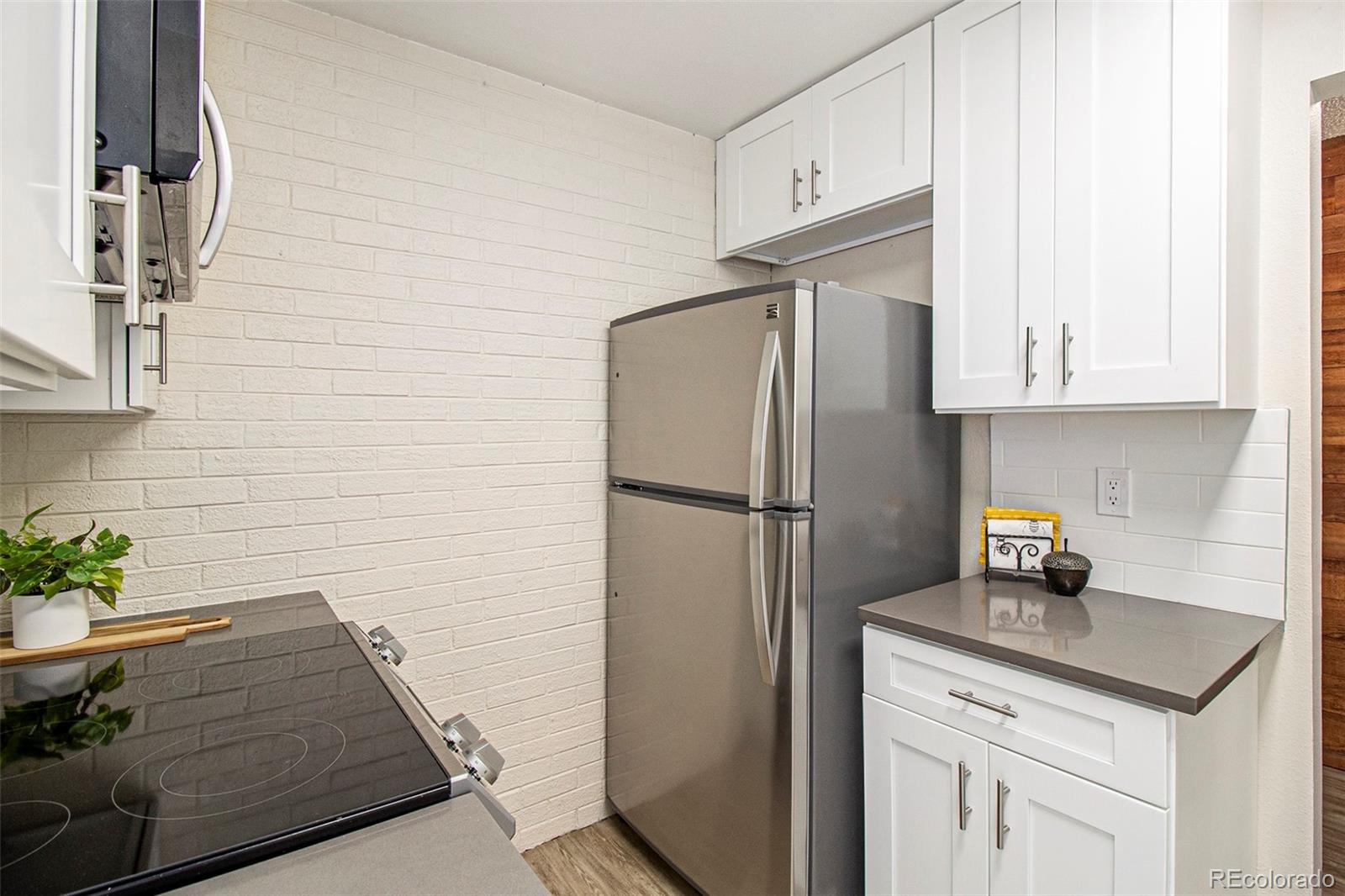 500 Manhattan Drive, Unit B1 Boulder, CO 80303 - Photo 10 of 24 a kitchen with stainless steel appliances white cabinets and a refrigerator