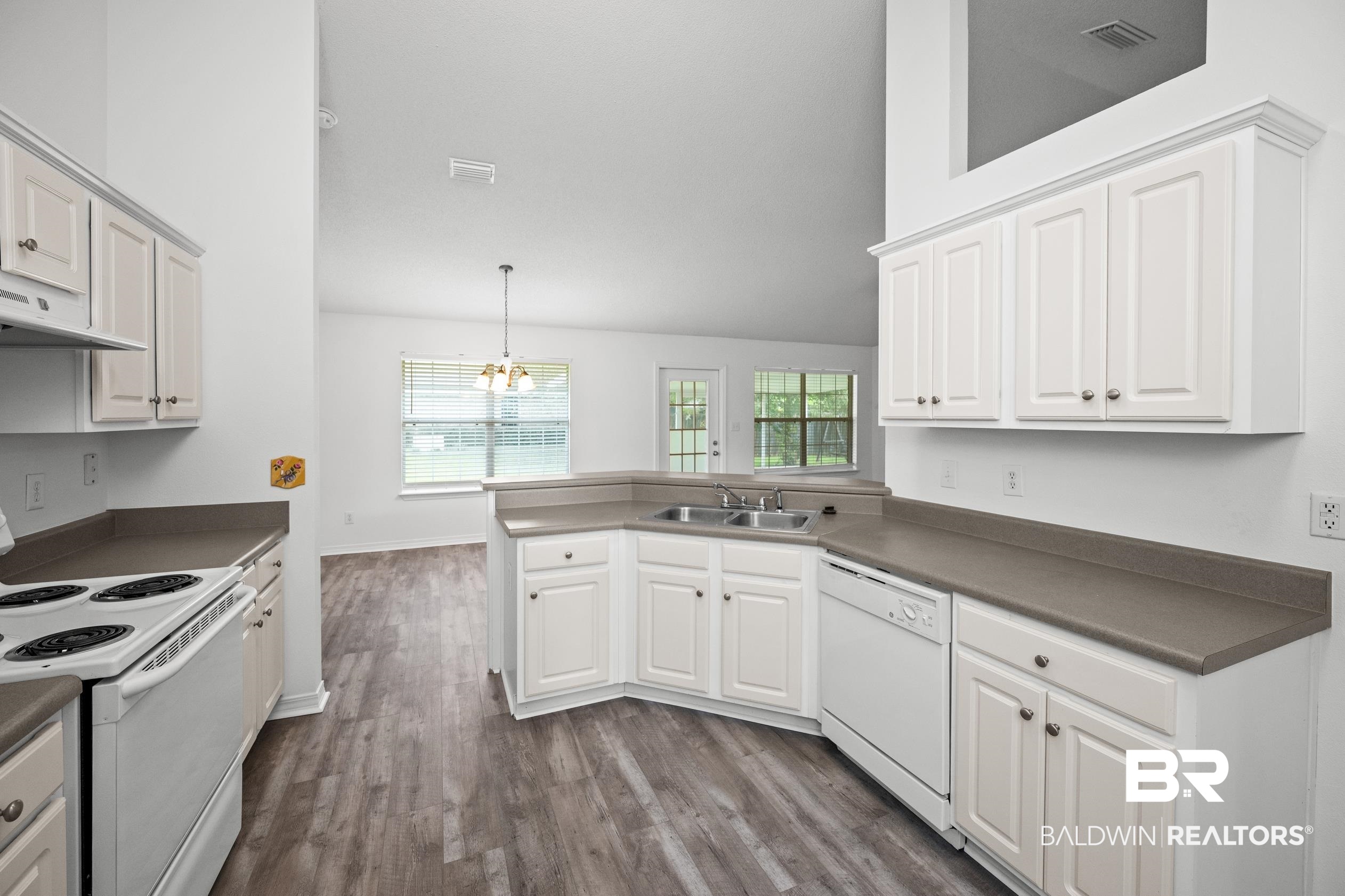 306 Monteith Oaks Drive Foley, AL 36535 - Photo 11 of 38 Kitchen featuring white appliances, dark wood-style floors, pendant lighting, a chandelier, and dark countertops