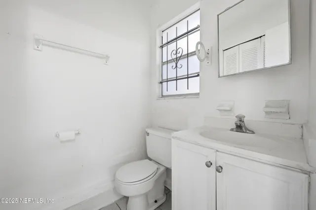 a bathroom with a sink a toilet and a window
