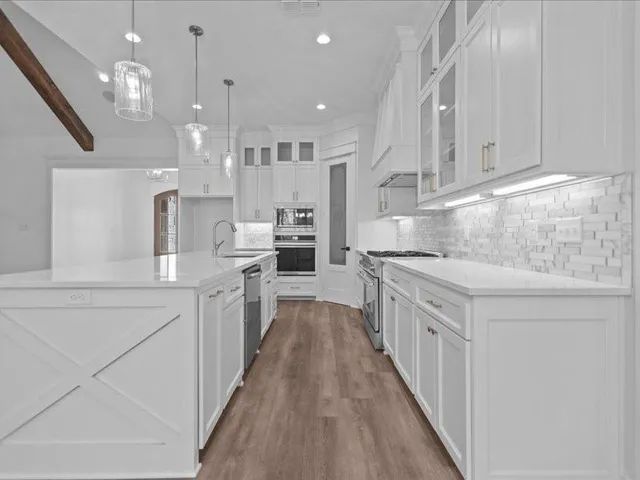 a kitchen with kitchen island granite countertop a sink cabinets and wooden floor
