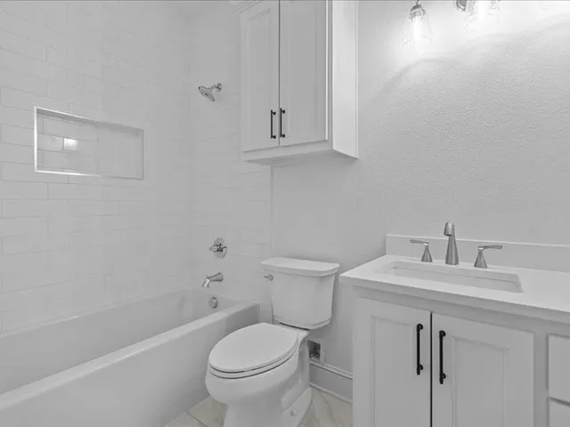 a spacious bathroom with a double vanity sink mirror and bathtub