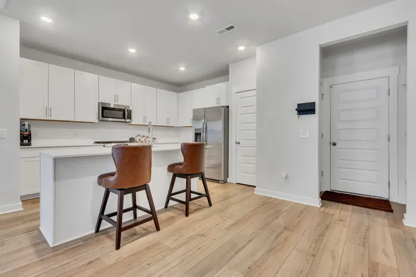 a kitchen with stainless steel appliances a refrigerator and a stove top oven