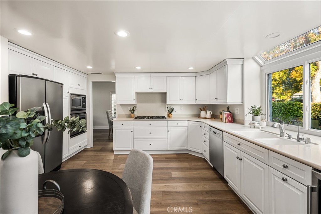 4 Abeto Irvine, CA 92620 - Photo 7 of 29 a large white kitchen with stainless steel appliances granite countertop a lot of counter space and a wooden floors