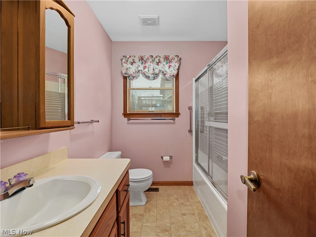 5175 Case Road North Ridgeville, OH 44039 - Photo 19 of 28 Full bathroom featuring oversized vanity, combined bath / shower with glass door, toilet, and tile floors
