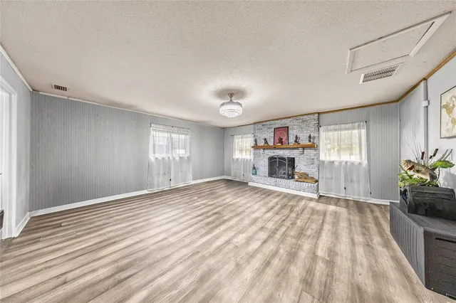 a view of an empty room with a window and fireplace