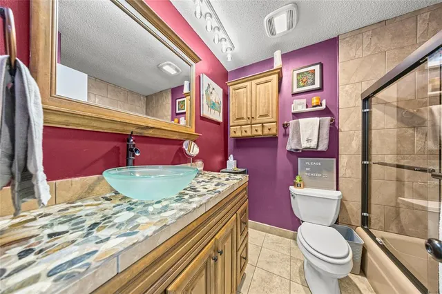 a bathroom with a granite countertop toilet a sink and a mirror