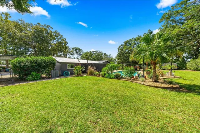 a view of a house with backyard and sitting area