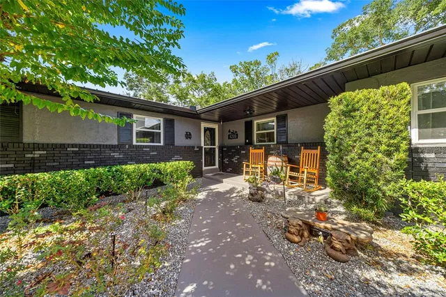 a view of a chair and table in backyard of the house