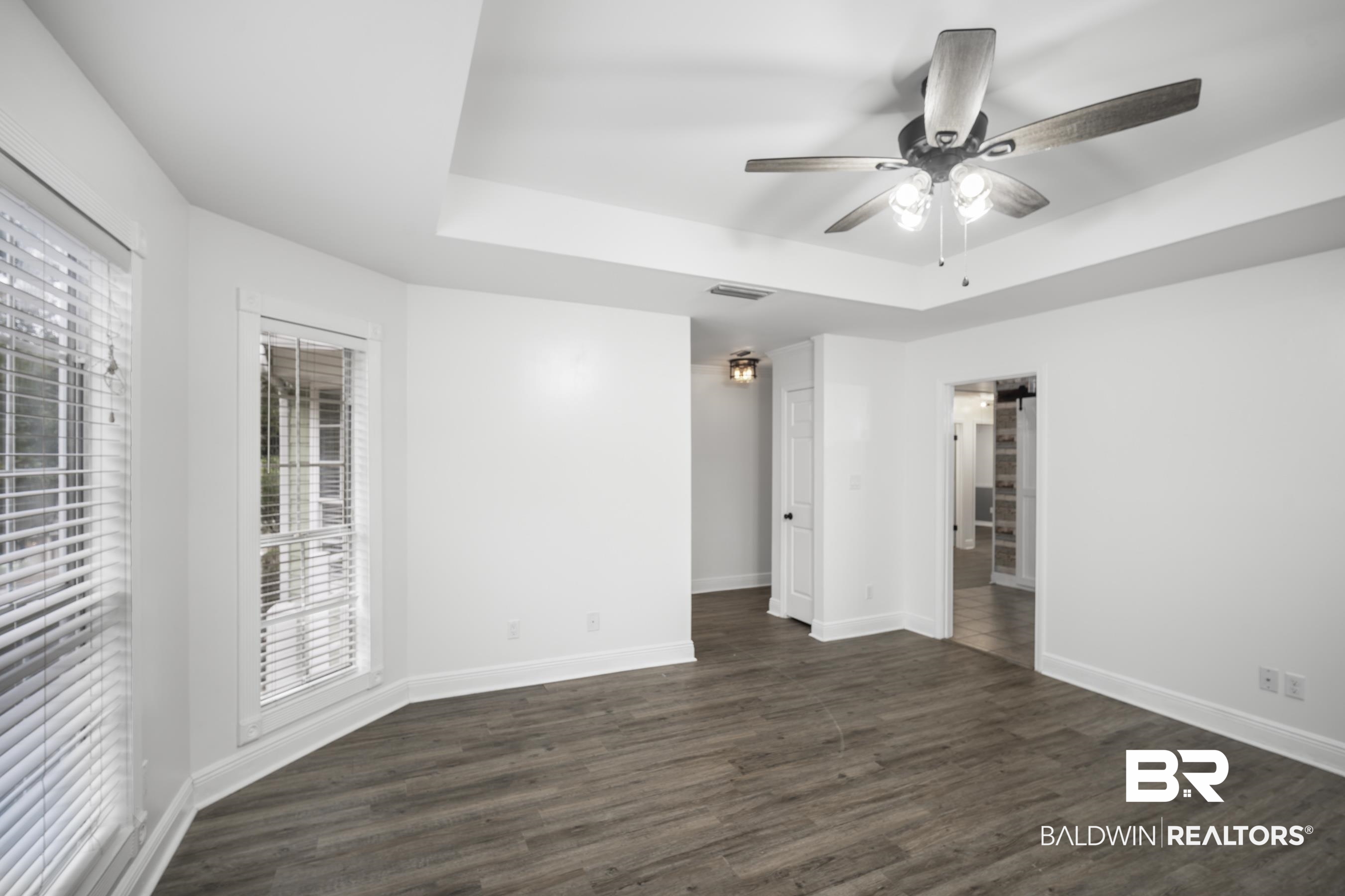 3101 Autumn Ridge Drive West Mobile, AL 36695 - Photo 13 of 36 Unfurnished room with a tray ceiling, dark wood-type flooring, and ceiling fan