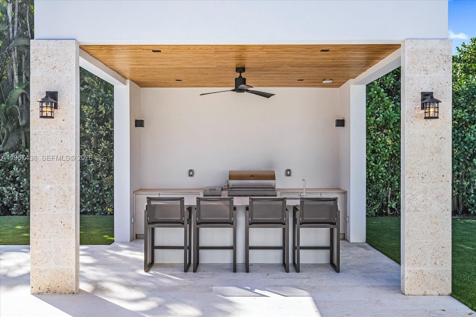 5902 Southwest 105th Street Pinecrest, FL 33156 - Photo 11 of 30 a patio with table and chairs and potted plants