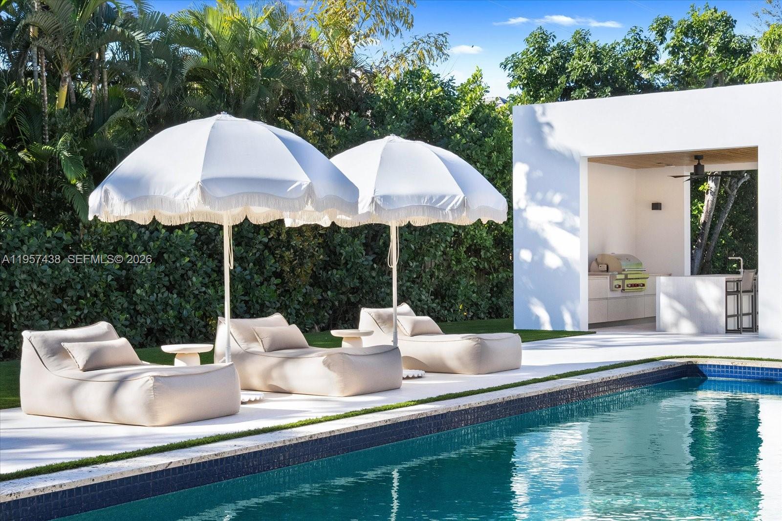 5902 Southwest 105th Street Pinecrest, FL 33156 - Photo 12 of 30 a view of a patio with lawn chairs under an umbrella