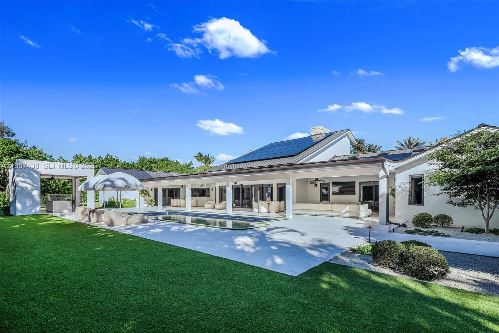 5902 Southwest 105th Street Pinecrest, FL 33156 - Photo 16 of 31 a front view of a house with a yard table and chairs