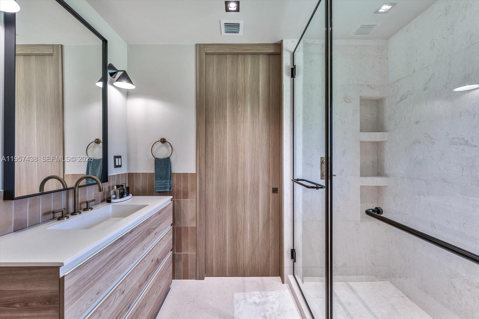 5902 Southwest 105th Street Pinecrest, FL 33156 - Photo 20 of 30 a bathroom with a double vanity sink and mirror