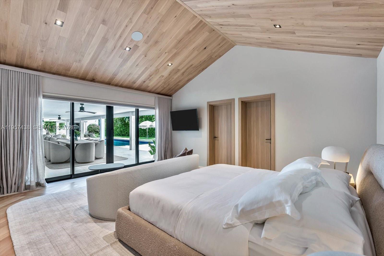 5902 Southwest 105th Street Pinecrest, FL 33156 - Photo 23 of 30 a large bed sitting in a bedroom next to a large window