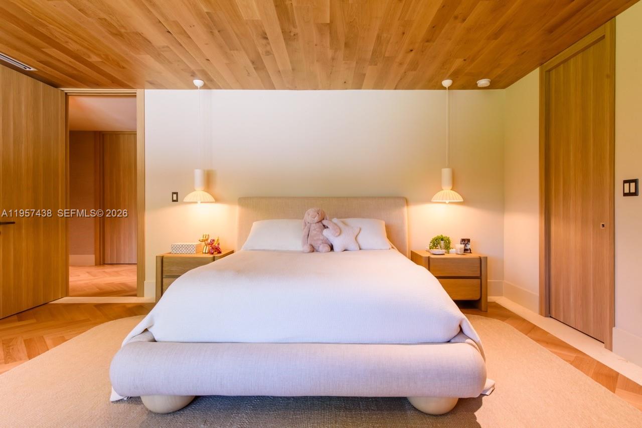 5902 Southwest 105th Street Pinecrest, FL 33156 - Photo 25 of 31 a bedroom with a bed and wooden floor