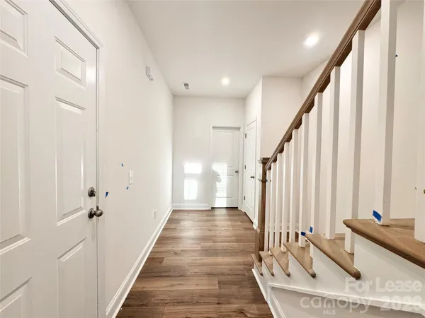 a view of a hallway with wooden floor and staircase