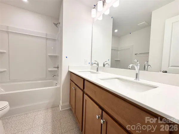 a bathroom with a sink a toilet a mirror and shower