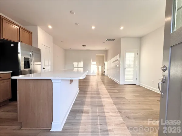 a large kitchen with stainless steel appliances kitchen island granite countertop a refrigerator and a sink