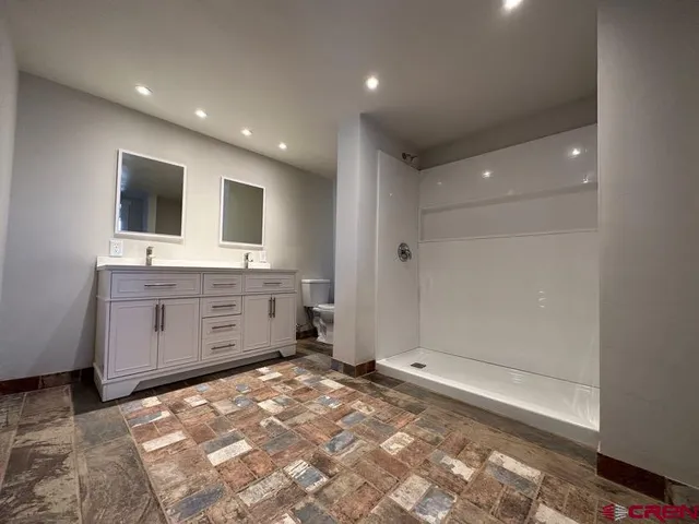 a bathroom with a sink a toilet and mirror