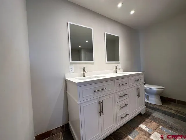 a bathroom with a double vanity sink and a mirror