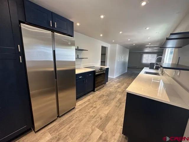 a kitchen with stainless steel appliances granite countertop a refrigerator a sink and a oven