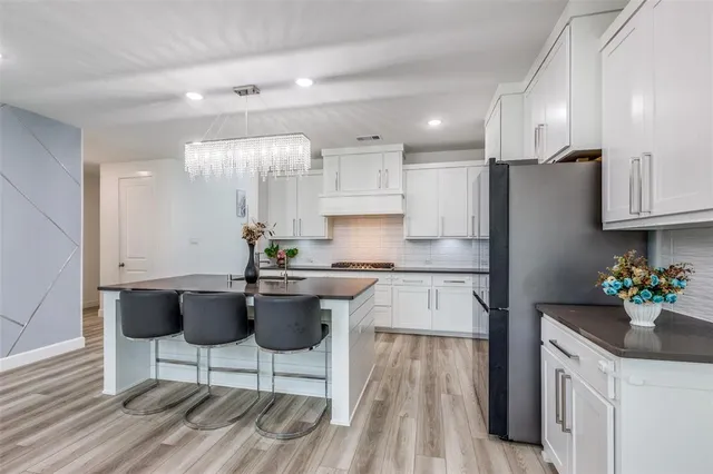 a kitchen with a sink refrigerator and cabinets