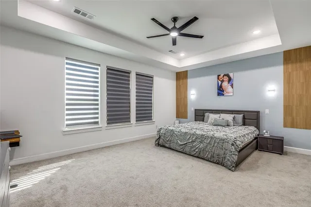 a spacious bedroom with a large bed and a chandelier