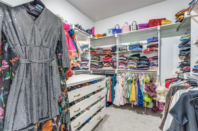 a view of walk in closet with clothes