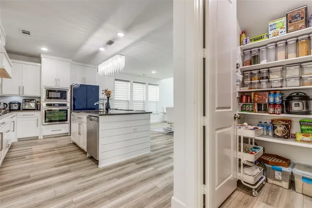a kitchen with stainless steel appliances kitchen island granite countertop a stove and a cabinets