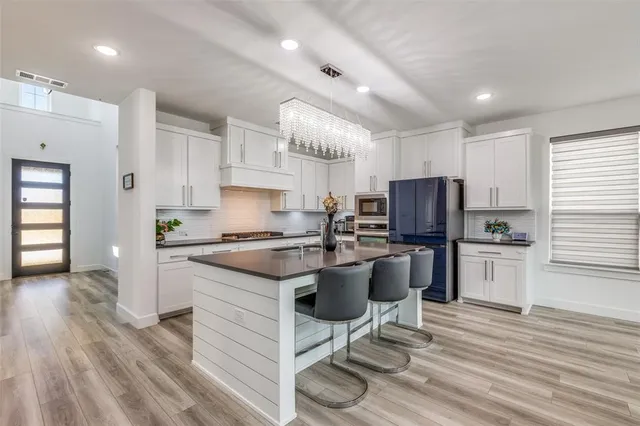 a kitchen with a refrigerator a stove cabinets and wooden floor