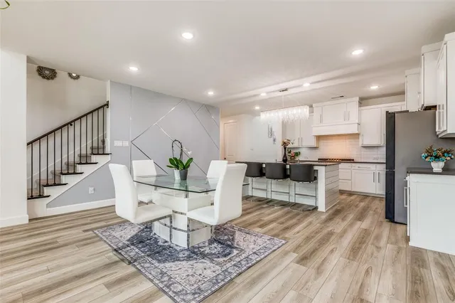 a living room with furniture and a dining table with wooden floor