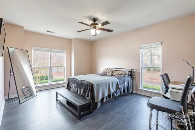 a spacious bedroom with a bed and a chair