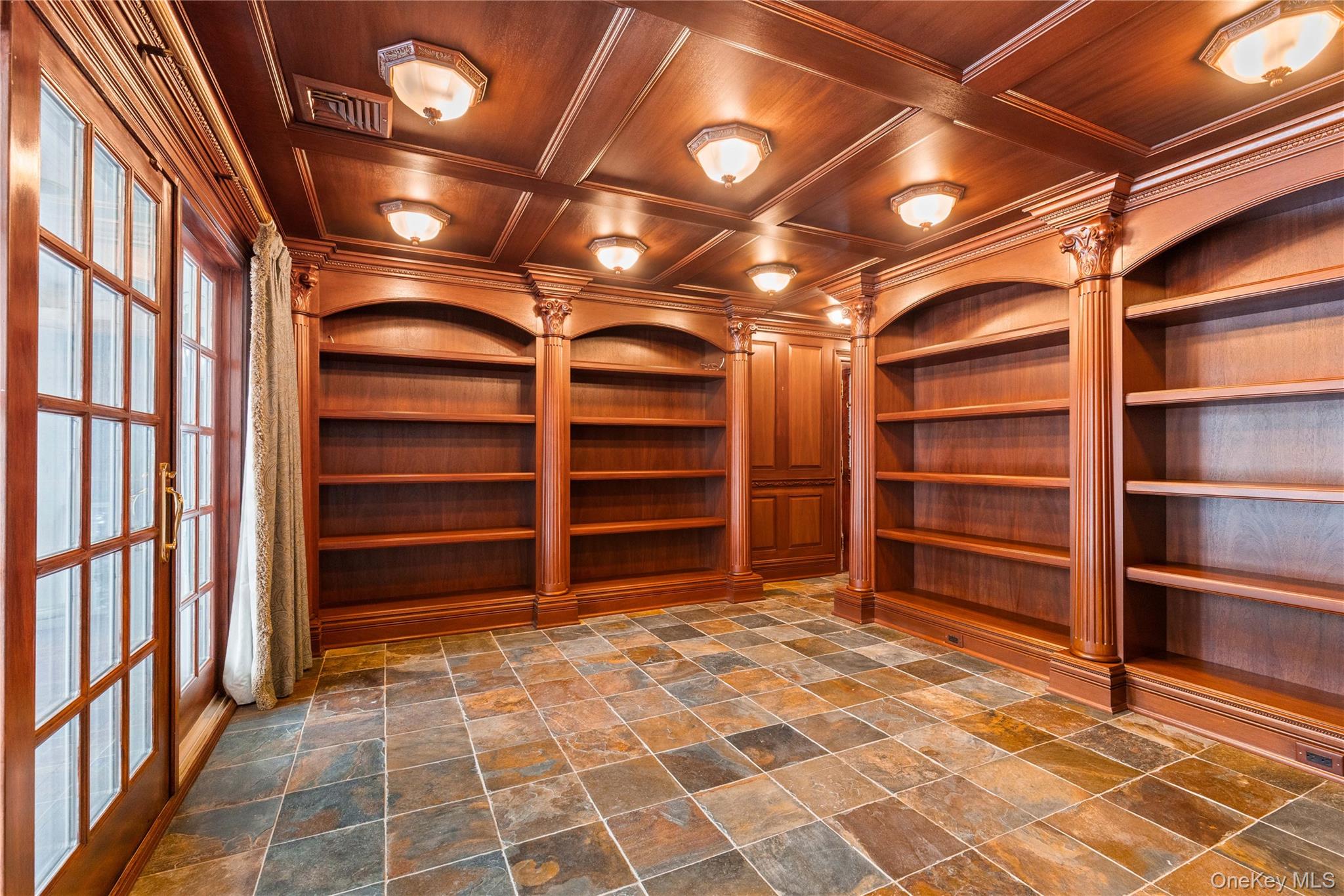 103 Pleasant Ridge Road Harrison, NY 10528 - Photo 7 of 39 Mahogany library crowned with custom built-ins, an intimate wood coffered ceiling with illuminated lighting, ornamental moldings, and dark stone finish floors -French doors out to deck & a side exit