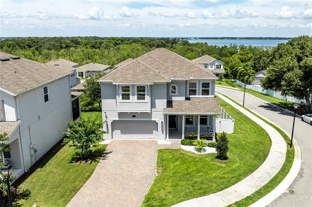 a front view of a house with a yard and trees