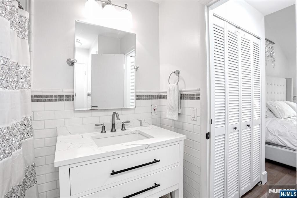 1110 River Road, Unit 105 Edgewater, NJ 07020 - Photo 15 of 19 a bathroom with a sink a mirror and shower