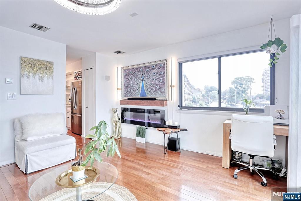 1110 River Road, Unit 105 Edgewater, NJ 07020 - Photo 6 of 19 a living room with furniture a fireplace and a table