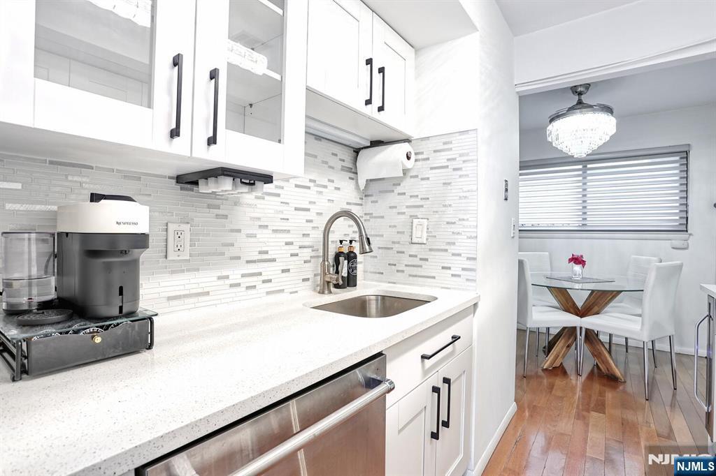 1110 River Road, Unit 105 Edgewater, NJ 07020 - Photo 9 of 19 a kitchen with a sink cabinets and wooden floor