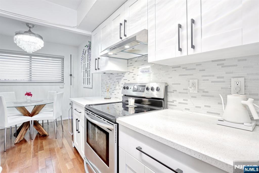 1110 River Road, Unit 105 Edgewater, NJ 07020 - Photo 10 of 19 a kitchen with stainless steel appliances granite countertop a stove and a sink