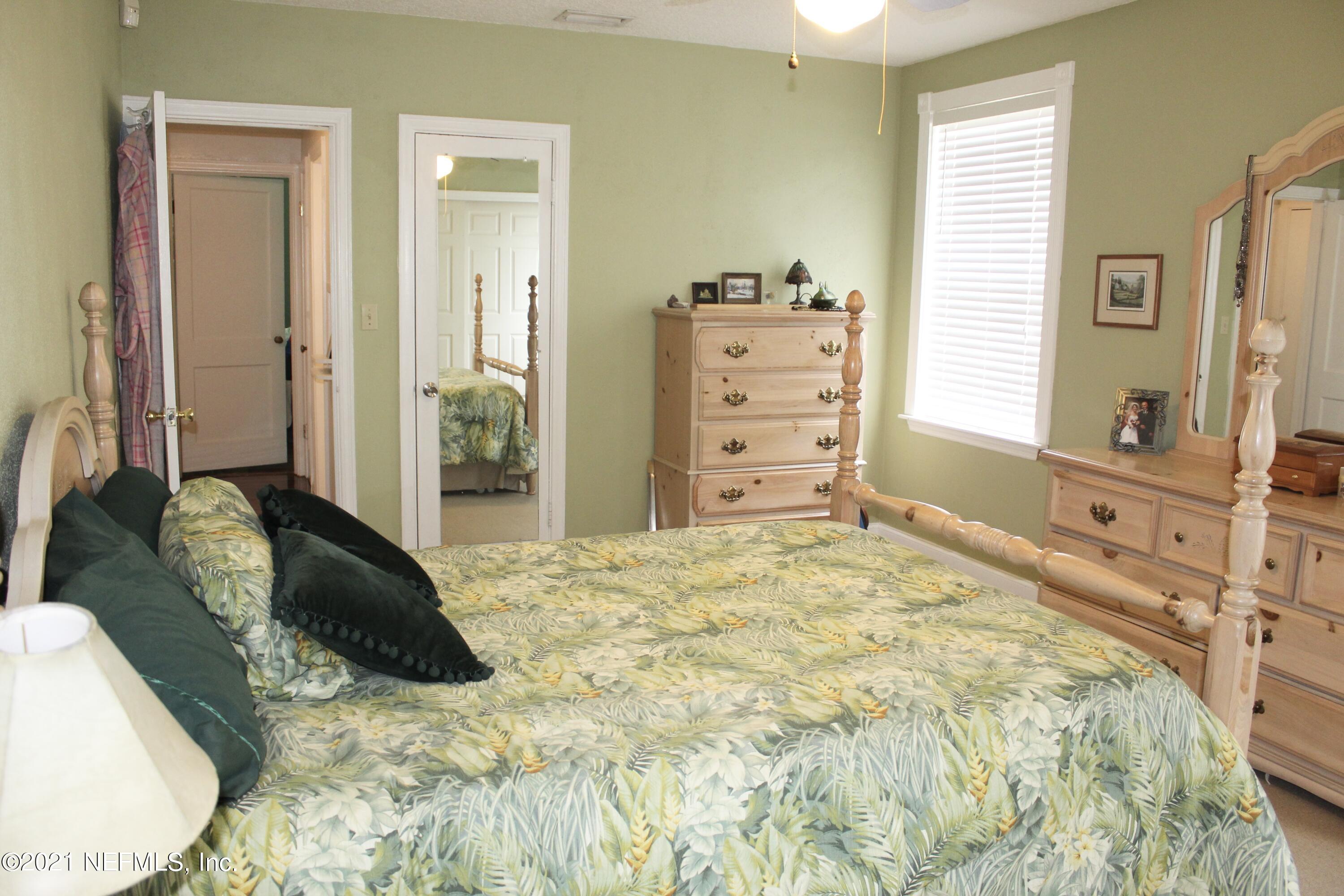 1840 Cornell Road Jacksonville, FL 32207 - Photo 16 of 24 a bedroom with a bed and dresser with mirror