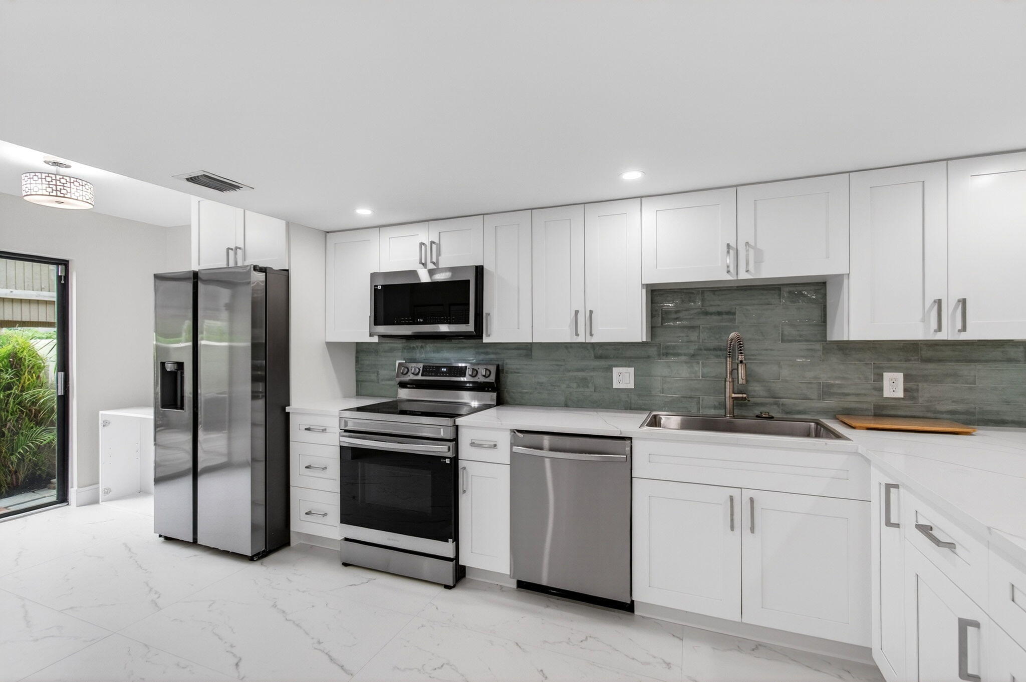 1330 Northwest 13th Street, Unit 12 Boca Raton, FL 33486 - Photo 9 of 52 a kitchen with white cabinets stainless steel appliances and sink