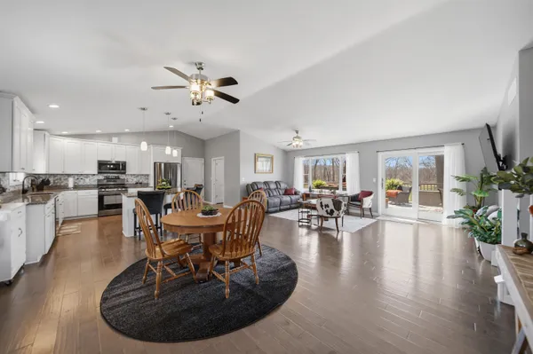 a living room with furniture kitchen view and a chandelier