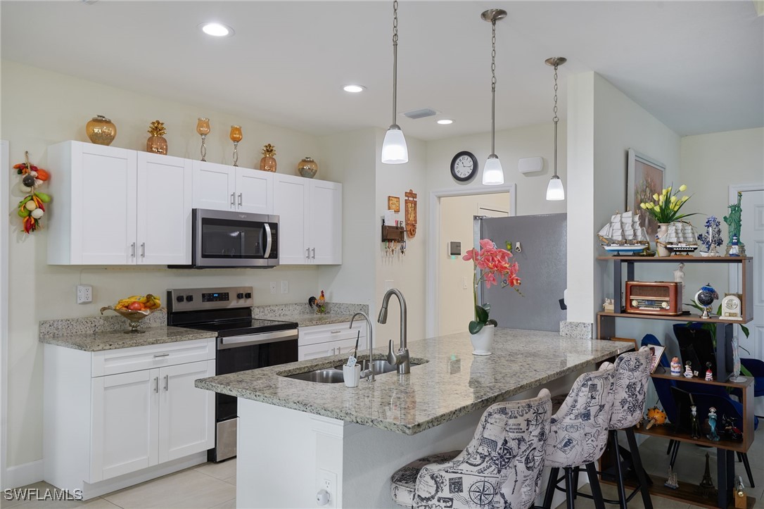 347 Ranier Avenue Lehigh Acres, FL 33974 - Photo 3 of 25 a kitchen with granite countertop a sink and cabinets