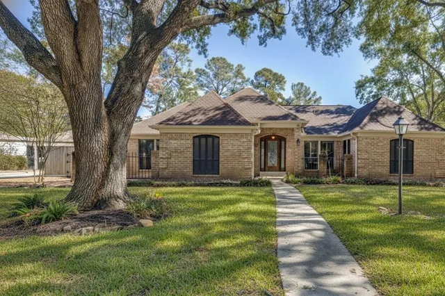 a front view of a house with a garden and trees