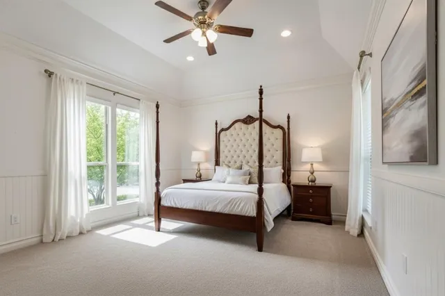a bedroom with a bed chandelier and a window