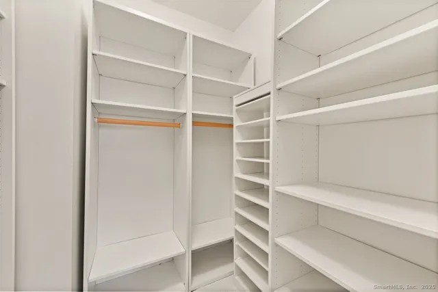 a view of walk in closet with empty racks